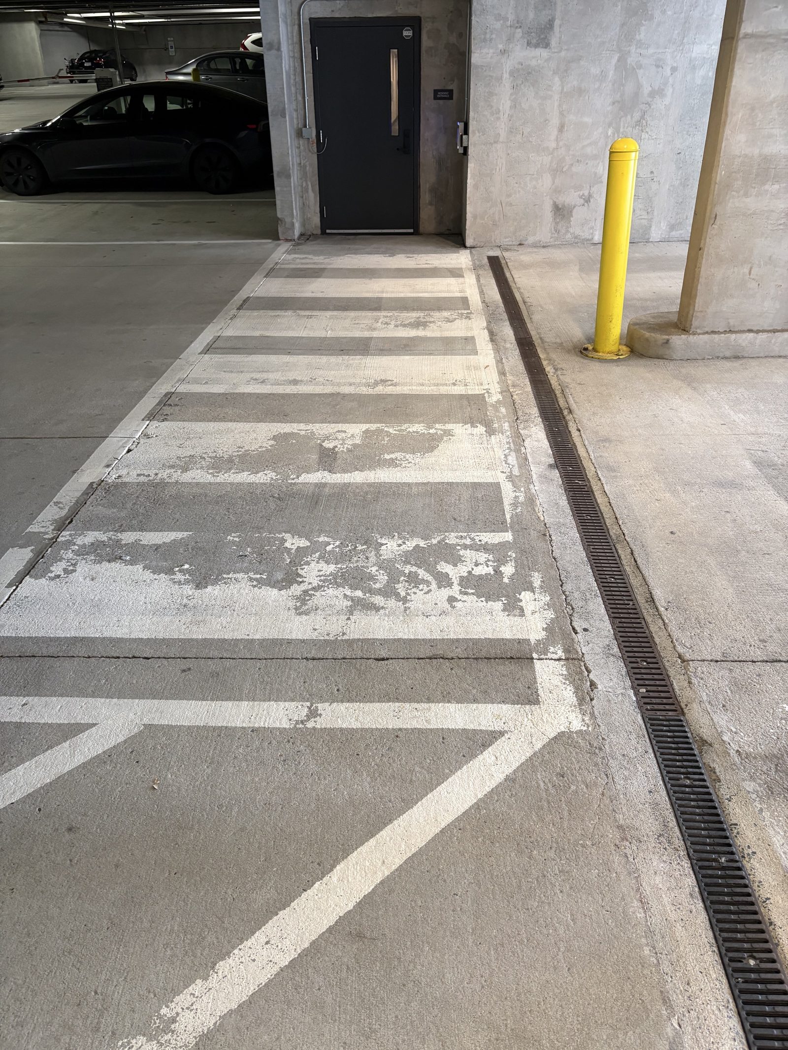 Worn parking garage crosswalk before line striping refresh